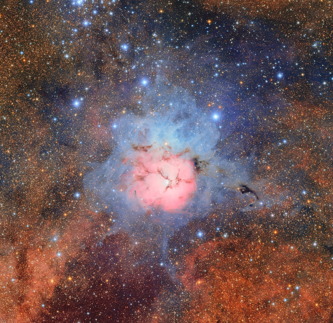 Pink and blue nebula amid a dense star field in space