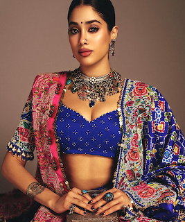Woman in blue blouse and colorful embroidered jacket wearing ornate silver necklace and ethnic jewelry