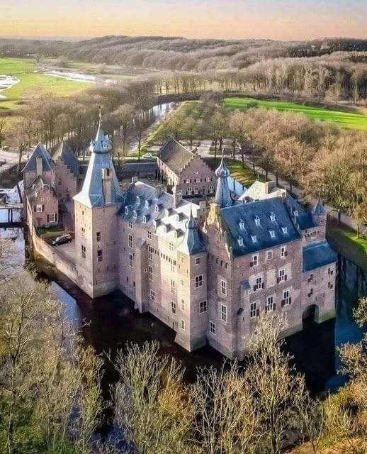 Heeswijk Castle, a moated Dutch medieval fortress with brick towers reflected in water