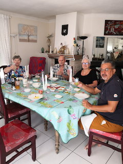 Four adults seated around a dining table in a bright home interior