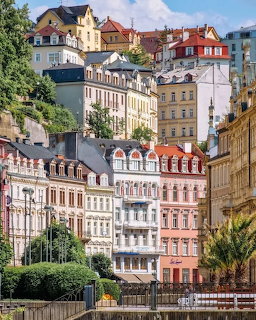 Colorful historic buildings on a hillside in Karlovy Vary, Czech Republic with ornate facades