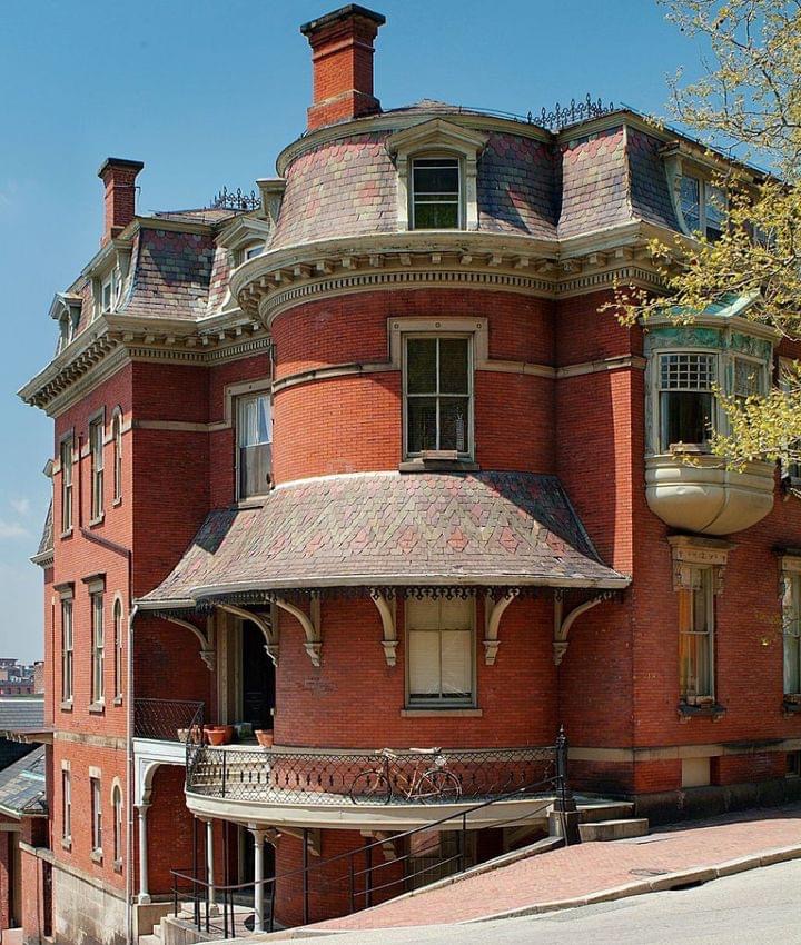 Victorian red brick corner house with turret and mansard roof on a hill in Providence RI