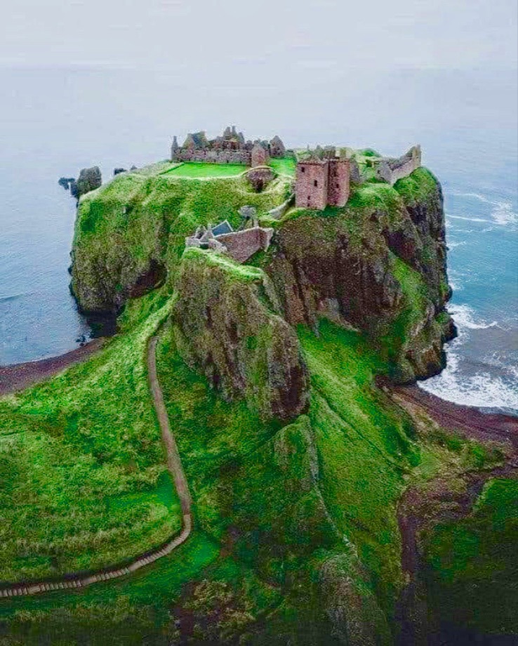 Dunnottar Castle ruins on a green clifftop peninsula above the sea