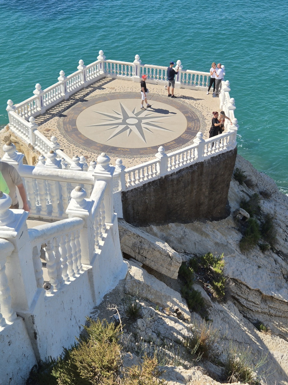 White ornate balcony viewpoint on rocky cliff above turquoise sea in Benidorm, Spain