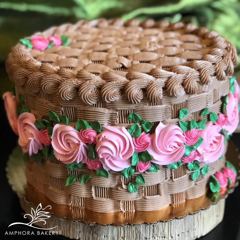 Chocolate cake decorated with basket-weave frosting and pink buttercream roses