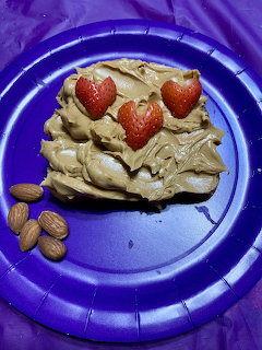 Toast with peanut butter, heart-shaped strawberries, and almonds on purple plate