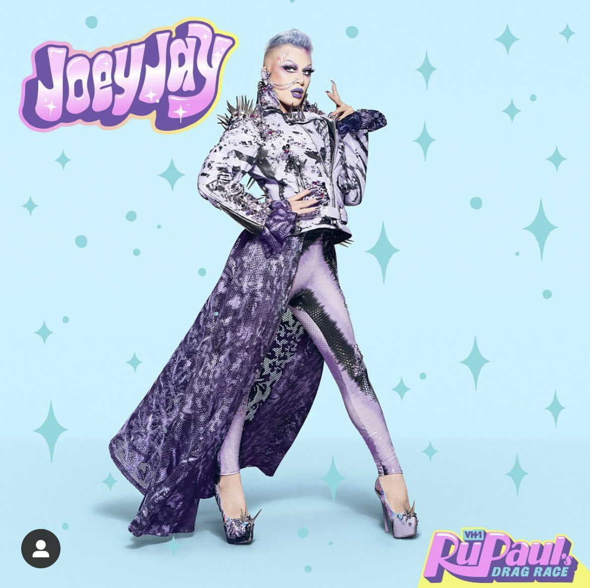 Joey Jay posing in a silver and purple drag outfit on a light blue starry background