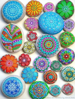 Assortment of circular painted stones with detailed mandala and flower designs in bright colors