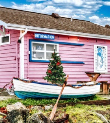 Pink beach cottage with Christmas tree and white boat in front yard