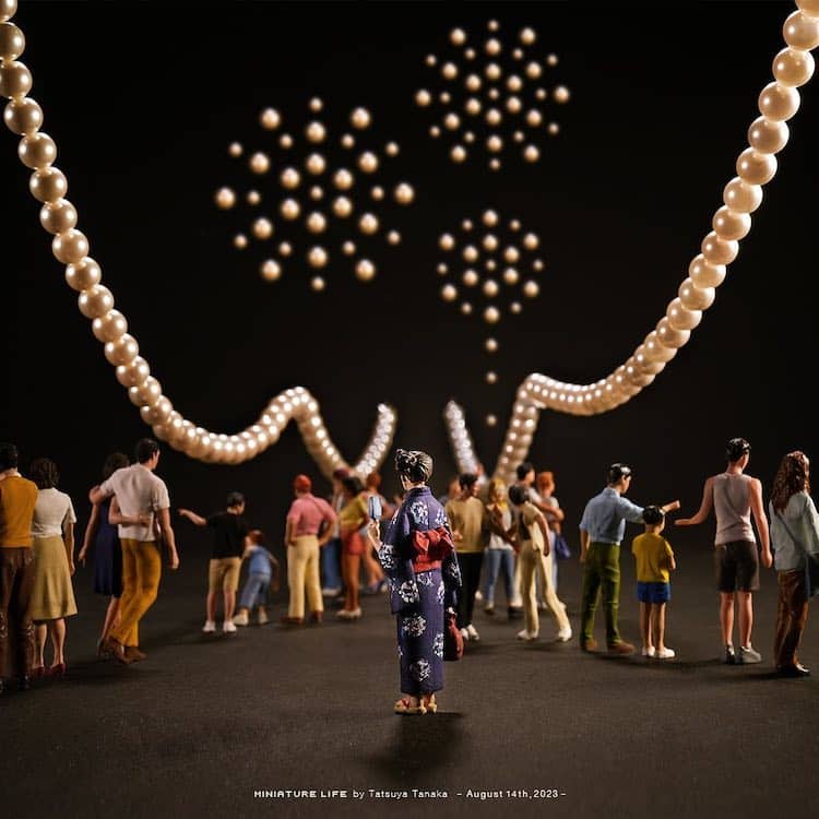 Miniature people figures watching fireworks made of beads and pearl necklace on black background