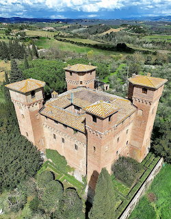 Aerial view of medieval Italian castle with four towers in green countryside