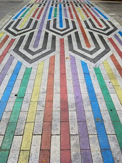 Colorful Art Deco brick pavement with geometric rainbow chevron pattern on outdoor walkway