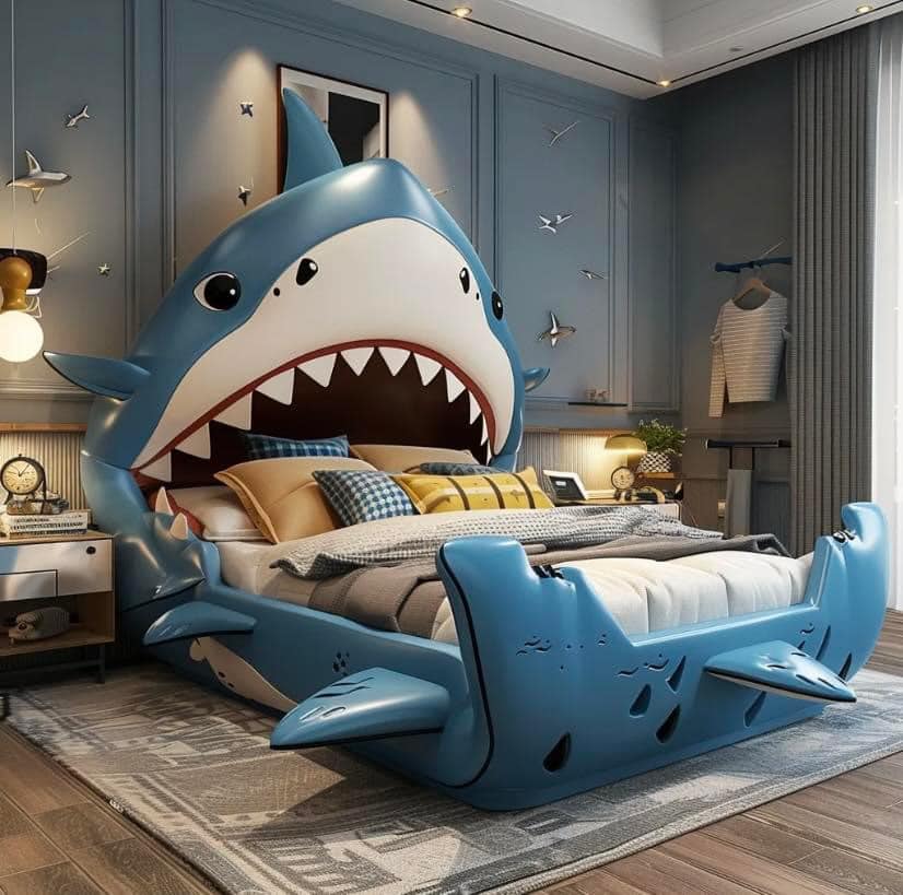 Blue shark-shaped bed in a modern bedroom with lamps, rug, and wall decor