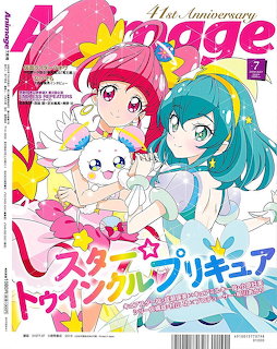 Magazine cover showing two anime magical girls in pink and blue costumes with a white cat mascot and star decorations