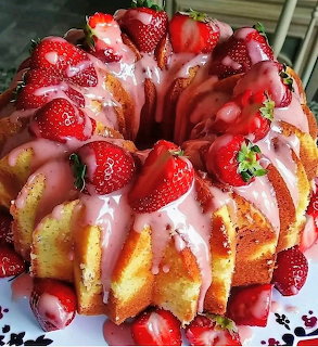 Bundt cake topped with fresh strawberries and pink icing