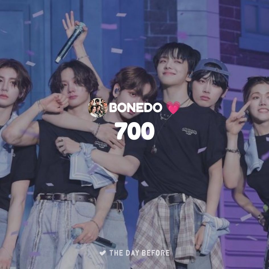 K-pop performer in black shirt with dancers on stage with purple city backdrop and '700' text overlay