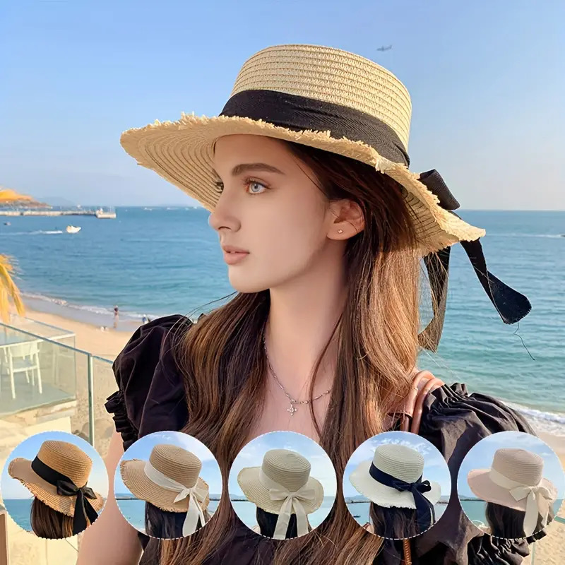 Woman in straw hat looking at ocean under blue sky