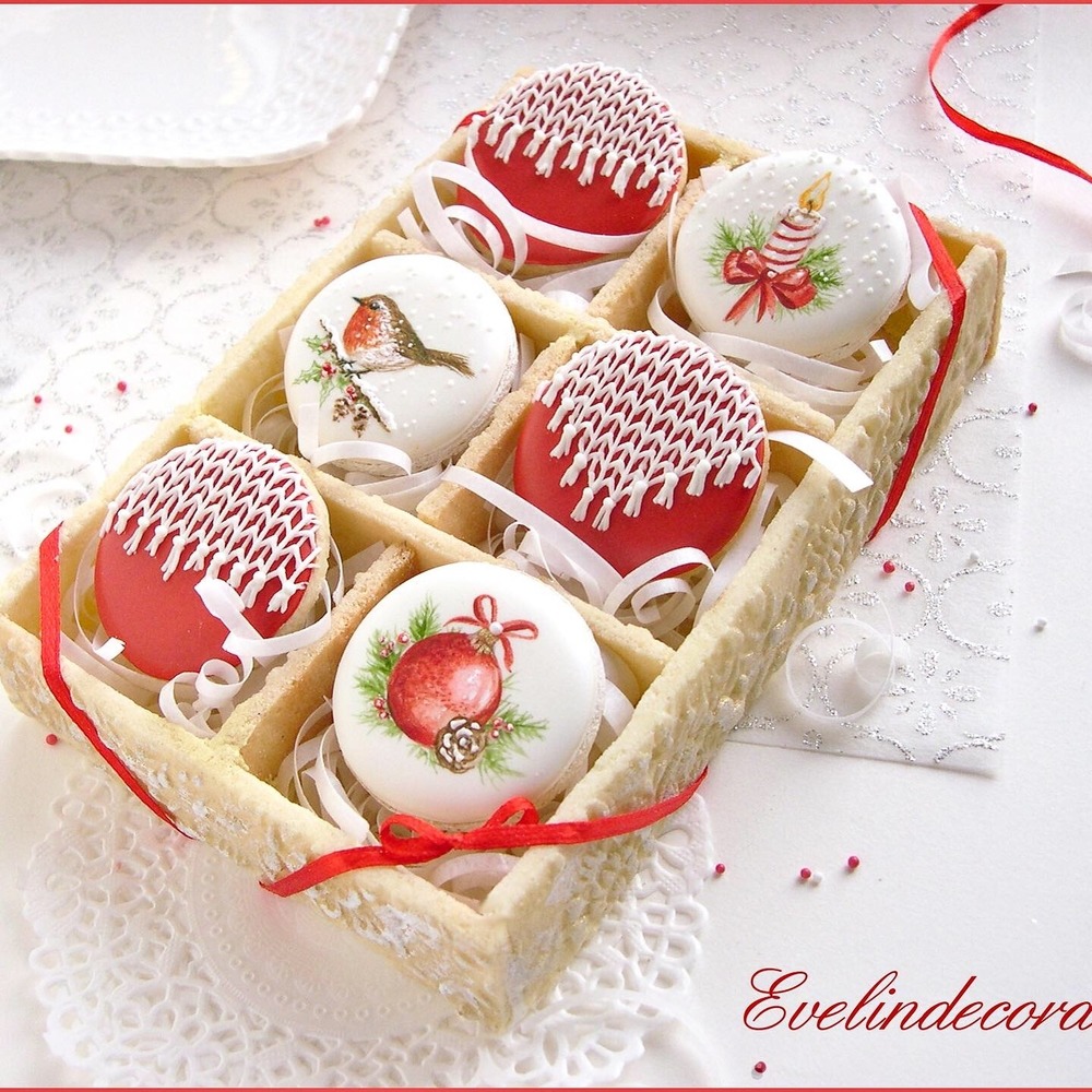 Six decorated Christmas cookies with red and white icing in wooden tray with holiday designs