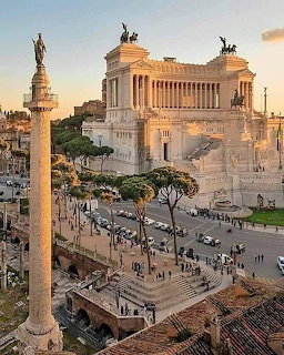 White marble Vittoriano monument in Rome with columns and equestrian statues at sunset