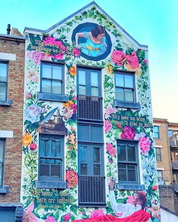 Building facade with colorful floral and butterfly mural surrounding windows