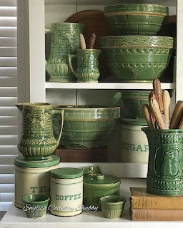 White shelves with green pottery crocks and bowls in country cottage style