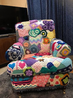 Armchair covered in colorful crochet granny square patches with rainbow patchwork patterns