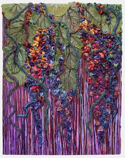 Textile art of purple wisteria flowers hanging from green leaves over striped background