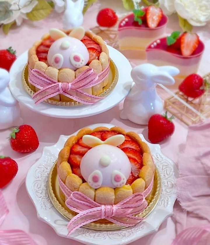 Cute kawaii pastries decorated with bunny faces, pink bows, and strawberries on white plates