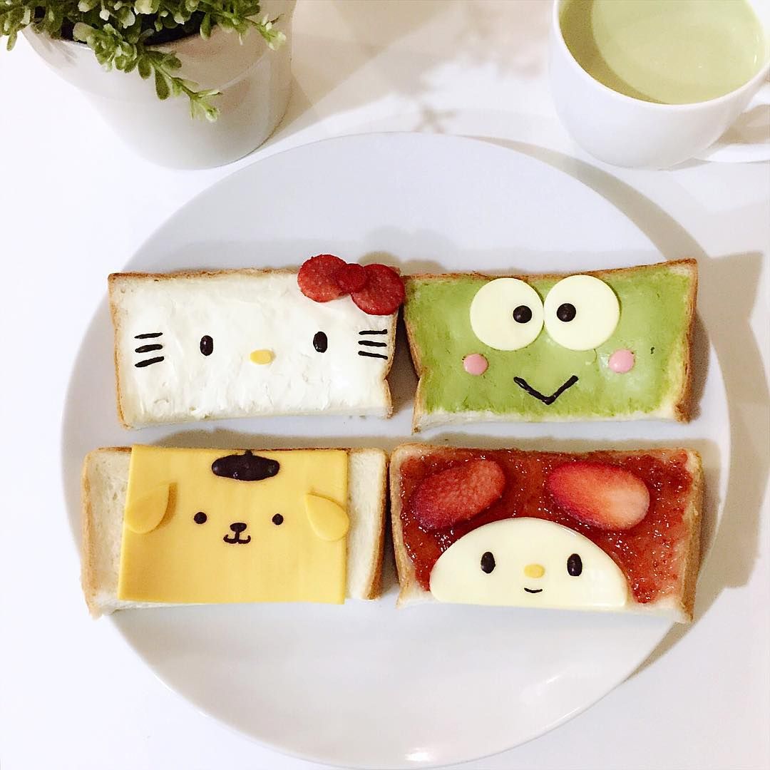 Four decorated toast slices styled as cute Sanrio characters with cream cheese and fruit arranged on a white plate