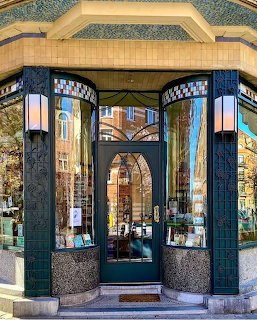 Art Deco style bookshop entrance with curved glass windows and ornate metalwork in Brussels