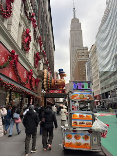 Macy's Thanksgiving parade float with giant turkey balloon on Manhattan street with Empire State Building in background