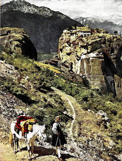 Monastery on cliff with stone bridge, mountain path, and travelers with animals
