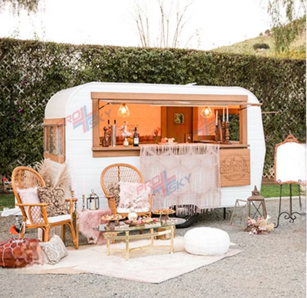Vintage caravan coffee bar with orange interior, wicker chairs, and decorative setup outdoors