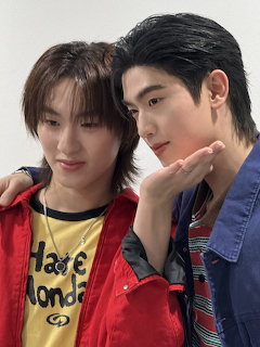Two young Asian men posing together, one in a red jacket and yellow shirt, the other in a blue denim jacket