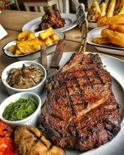 Grilled lamb chops with roasted potatoes and vegetables on white serving platter