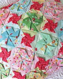 Handmade patchwork quilt with colorful pinwheel star blocks in floral fabrics