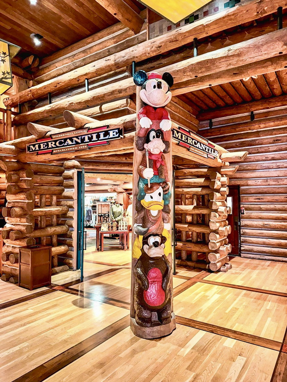 Wooden totem pole with Disney character carvings in a log cabin store at Fort Wilderness Lodge