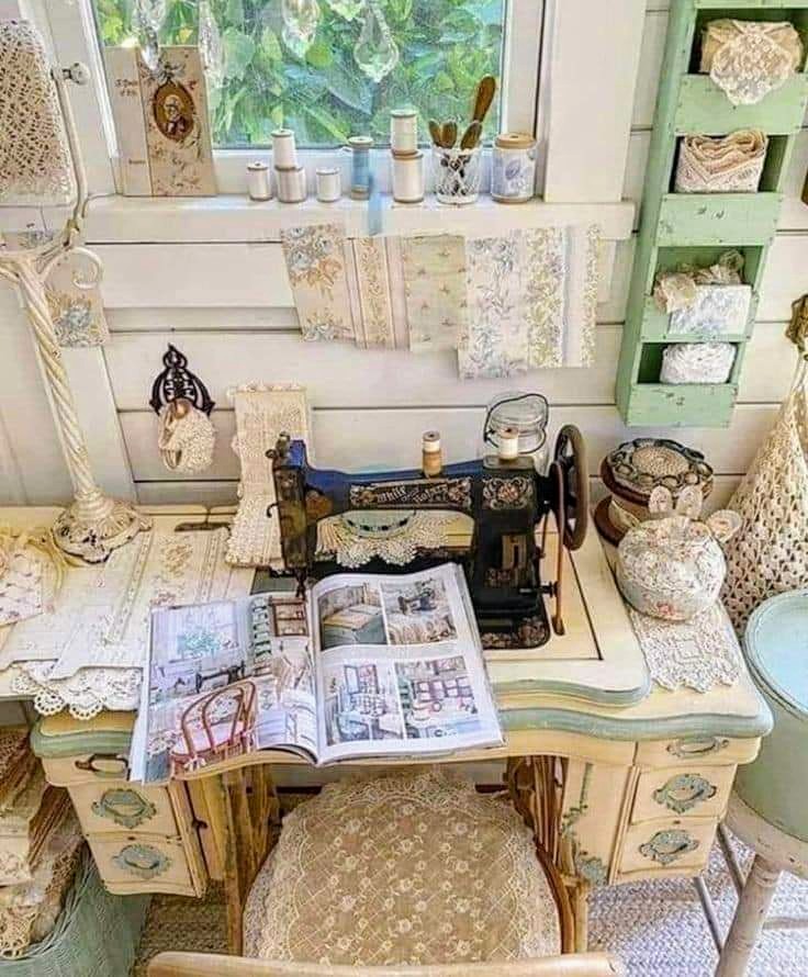 Vintage sewing room with antique sewing machine, lace curtains, wooden furniture and craft supplies on shelves