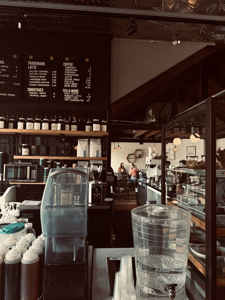 Interior of a coffee shop with menu boards, product shelves, seating, and warm ambient lighting