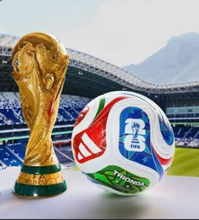 FIFA World Cup trophy and soccer ball on a table inside a stadium