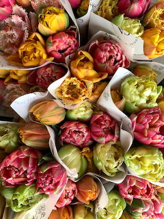 Close-up of wrapped bouquets of colorful tulips in pink, yellow, orange, and green
