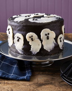 Chocolate Halloween cake with white ghost decorations on silver stand