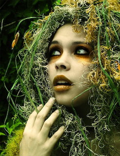 Woman's face decorated with moss and natural green foliage in artistic portrait