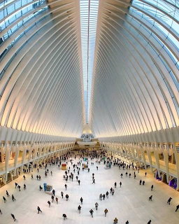 White ribbed interior of Oculus NY transportation hub with dramatic curved ceiling and people walking below