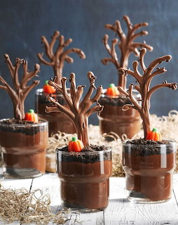 Halloween chocolate pudding desserts with pretzel trees and candy pumpkins in clear cups