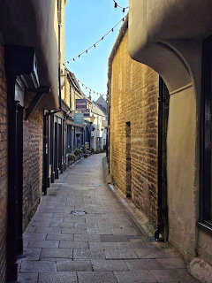 Narrow stone alley with archways and bunting in historic English town