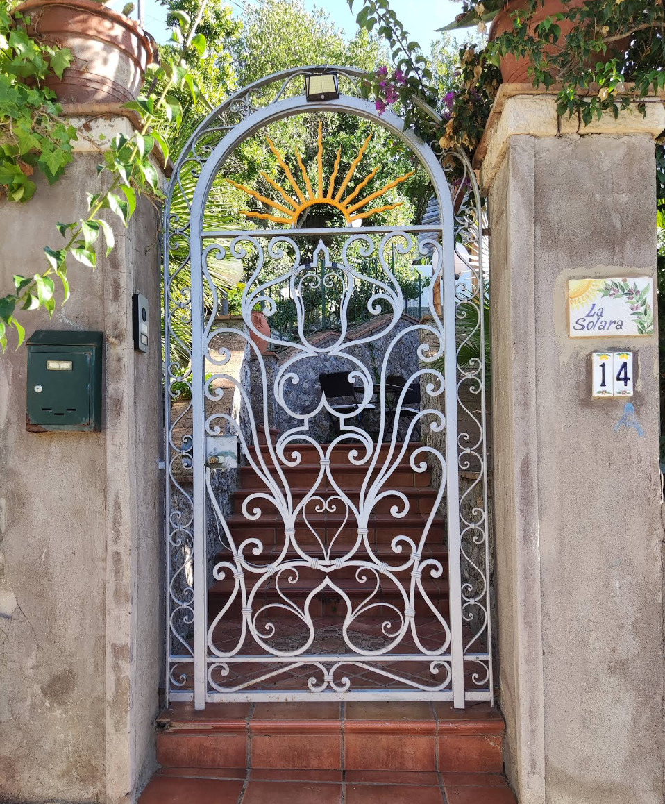 Stone arched gateway with whitewashed walls and tiled steps on Capri