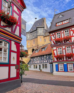 Colorful half-timbered houses and medieval tower on cobblestone street in Bavarian village