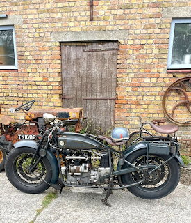 Vintage black FN motorcycle parked against a brick wall