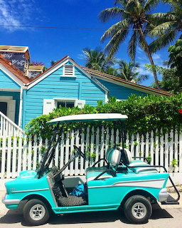 Pastel golf cart on a sandy street near the beach on Harbour Island, Bahamas